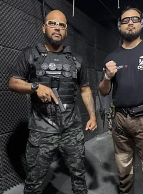Dois instrutores com equipamento tático em estande de tiro